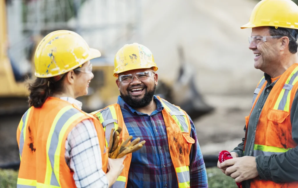 Three construction workers chatting happily.